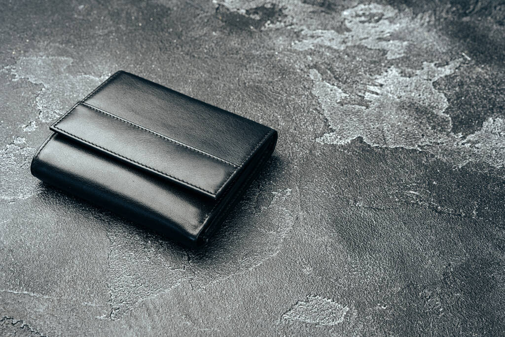 Νέο μαύρο δερμάτινο πορτοφόλι σε σκούρο φόντο - Φωτογραφία, εικόνα