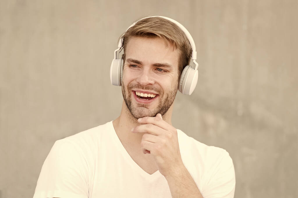Noise Reduction. Wireless Earpiece. Handsome guy wear headphones grey background. Man listen modern music. Modern technology. Modern and contemporary music. Hobby leisure. Foldable Stereo Headphones - Photo, Image