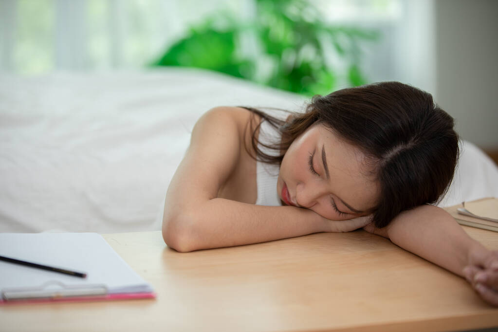 Asiatico giovane donna sonno su lavoro tavolo in camera da letto - Foto, immagini