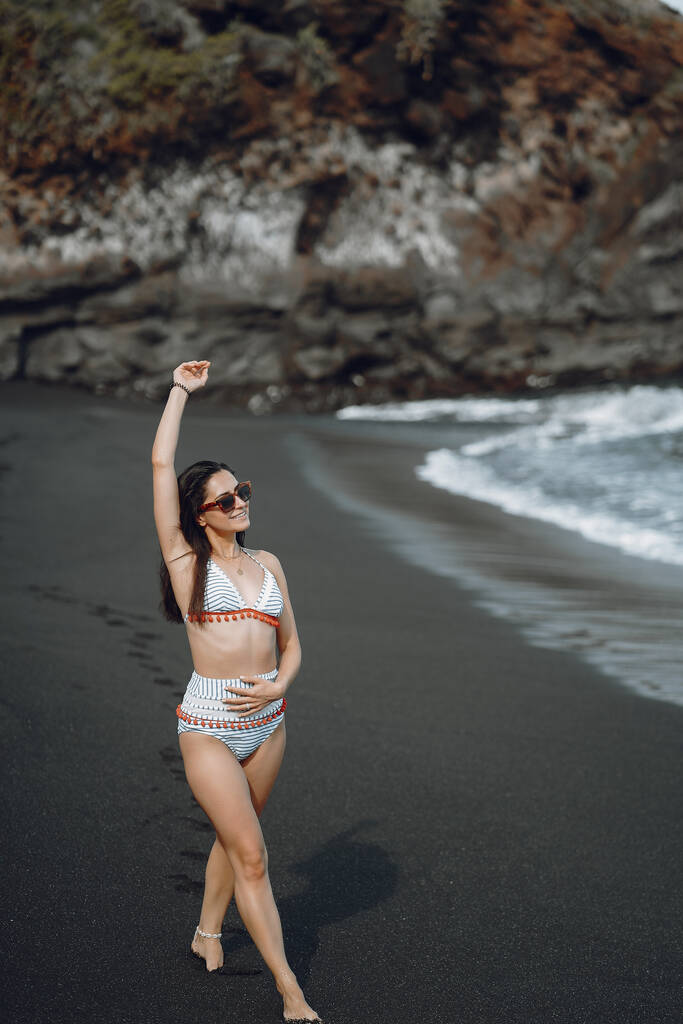 Meisje in stijlvol badpak houden rust n het strand - Foto, afbeelding