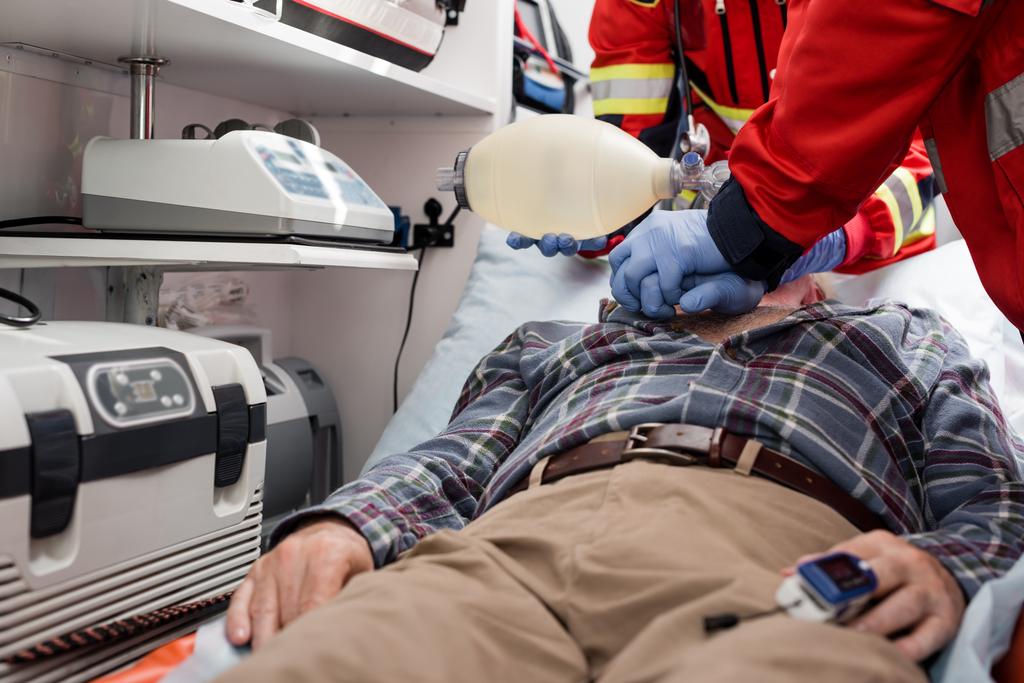 A kardiopulmonális újraélesztést végző mentősök szelektív fókusza a szívfrekvenciás monitorral rendelkező beteghez a mentőautóban  - Fotó, kép