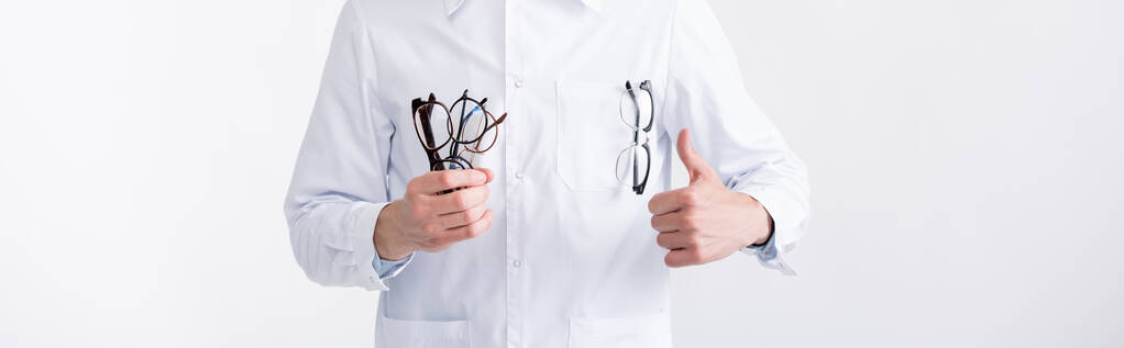 Oříznutý pohled na oftalmologa s palcem nahoru, s několika brýlemi izolovanými na bílém, banner - Fotografie, Obrázek