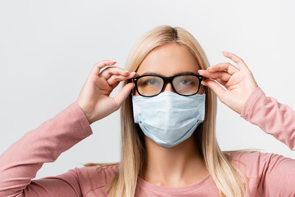 Молода жінка в медичній масці тримає помилкові окуляри ізольовані на сірому
 - Фото, зображення