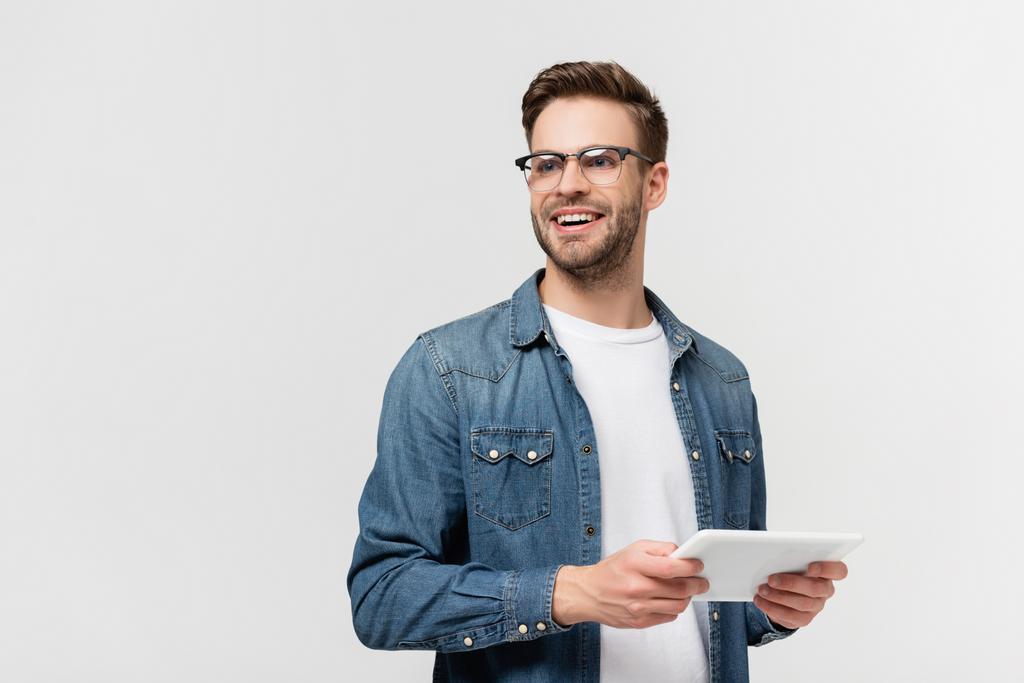 Uśmiechnięty mężczyzna w okularach trzymający cyfrową tabletkę odizolowaną na szaro - Zdjęcie, obraz