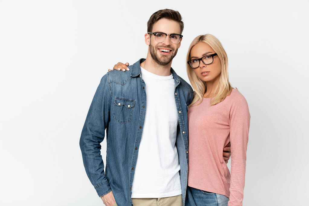 Mulher loira abraçando namorado sorridente em óculos isolados em cinza - Foto, Imagem