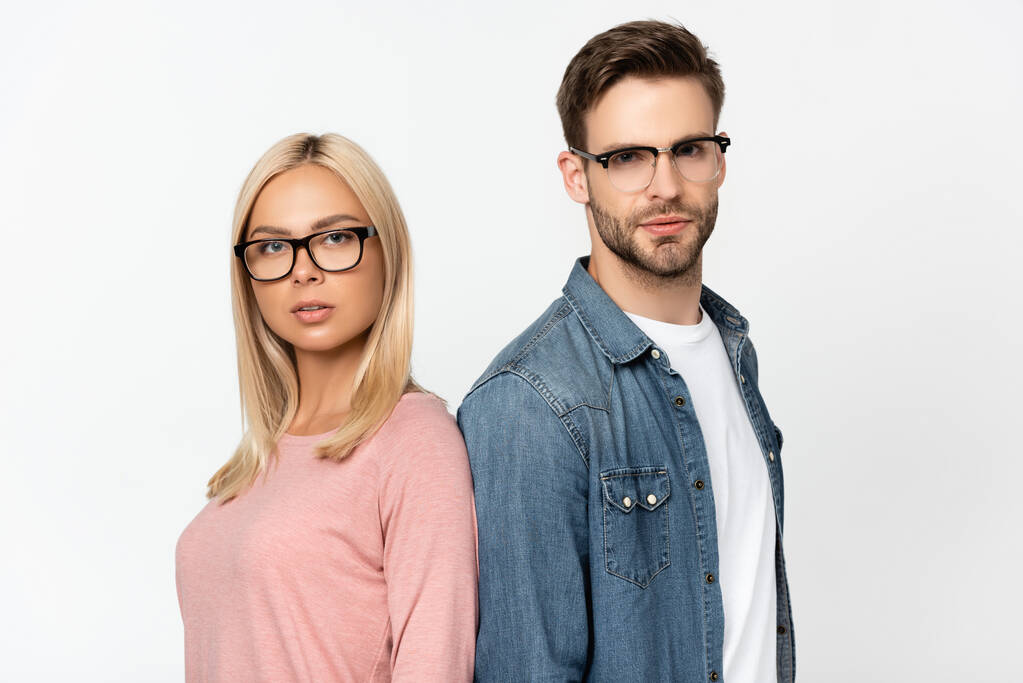 Paar mit Brille blickt in Kamera, während es isoliert auf grau steht - Foto, Bild