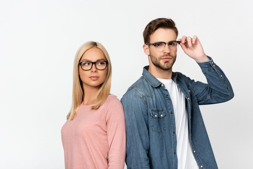 Young man touching eyeglasses near blonde girlfriend isolated on grey - Photo, Image