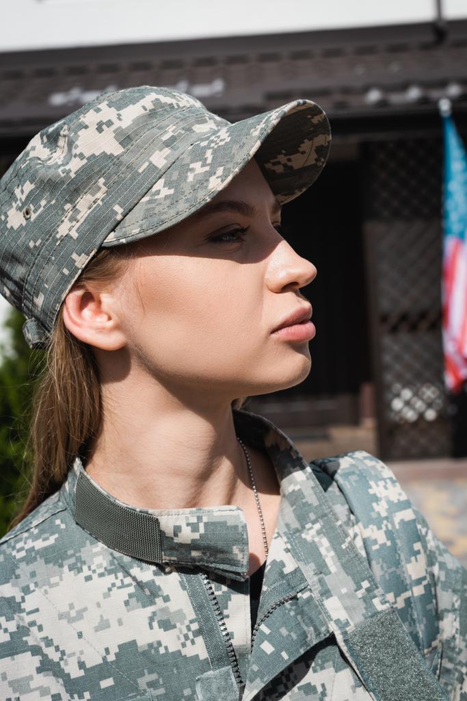 Porträt einer selbstbewussten Militärfrau in Uniform, die auf verschwommenem Hintergrund wegschaut - Foto, Bild