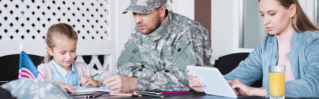 Wojskowy żołnierz siedzi w pobliżu dziewczyna rysunek i kobieta za pomocą tabletu cyfrowego w domu, baner - Zdjęcie, obraz