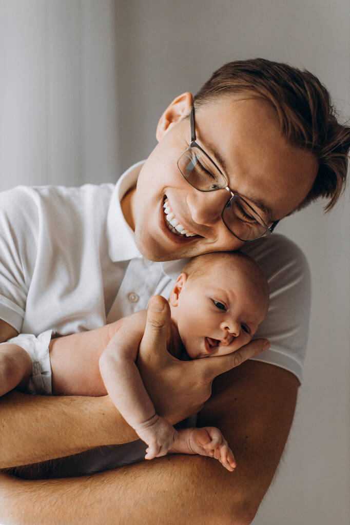 Opiekuńczy ojciec z uroczym noworodka dziewczynka, przystojny tata trzymać w ramionach piękna córeczka, cieszyć się szczęśliwe chwile rodzicielskie, uśmiech, ojcostwo koncepcja - Zdjęcie, obraz