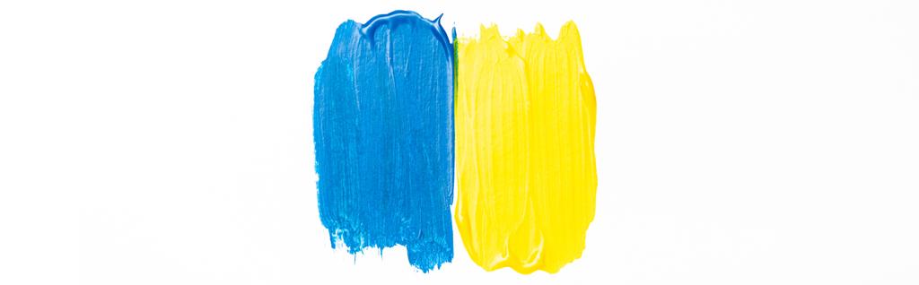 Draufsicht auf abstrakte, bunte blaue und gelbe Pinselstriche auf weißem Hintergrund, Panoramaaufnahme - Foto, Bild