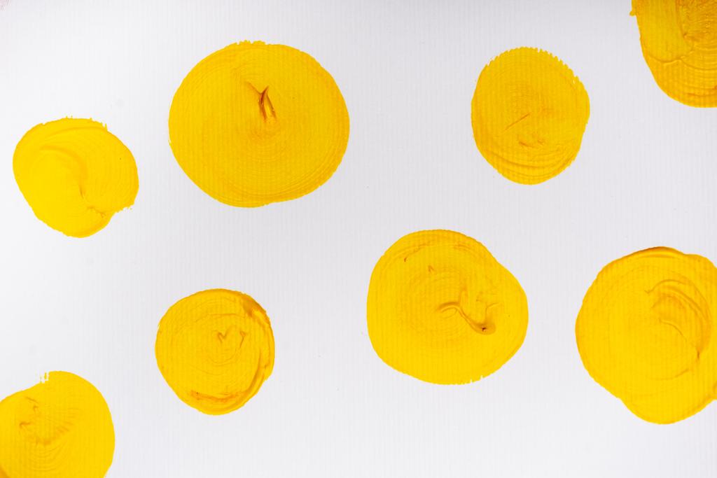 felső nézet elvont színes sárga festett körök fehér háttér - Fotó, kép