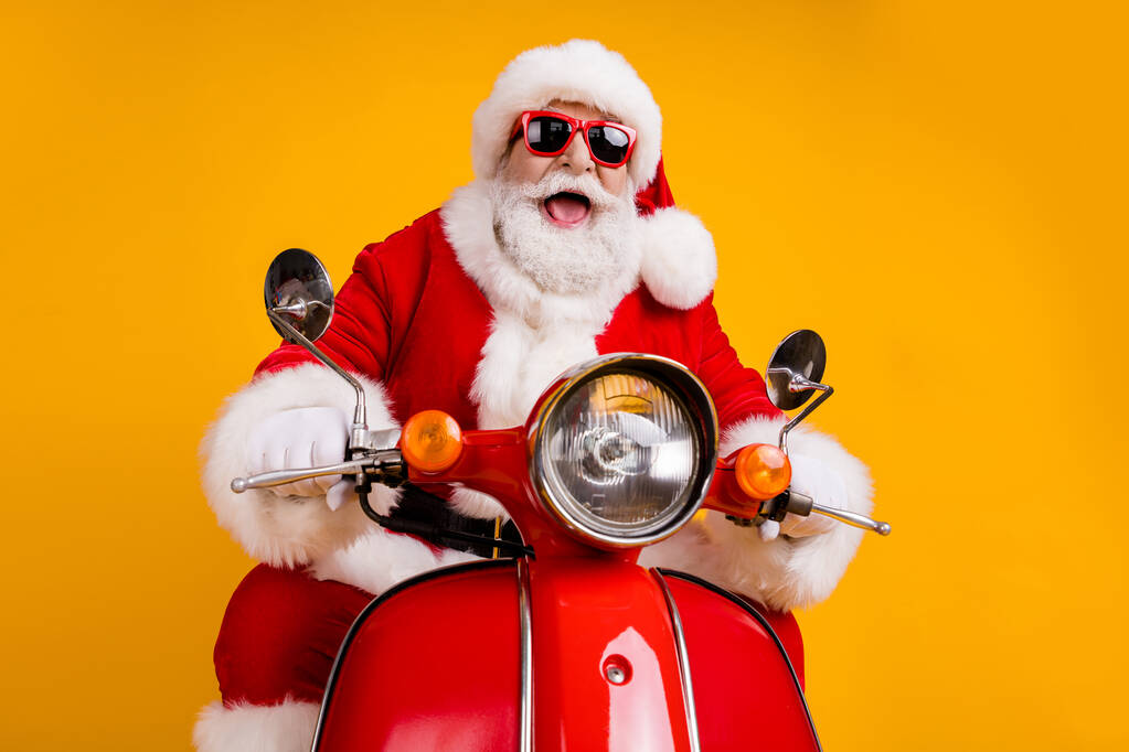 Portrait of his he nice funny cheerful cheery cool hipster Santa riding moped fast speed travel road way trip having fun leisure isolated bright vivid shine vibrant yellow color background - Photo, Image