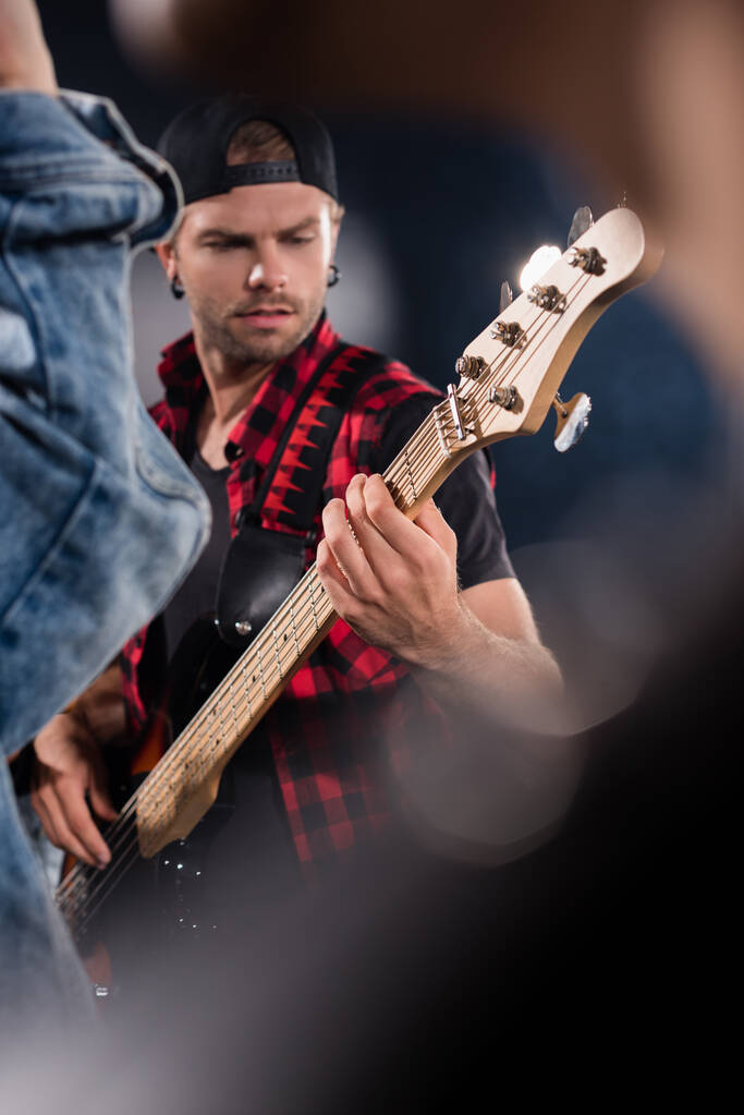 KYIV, UCRANIA - 25 de agosto de 2020: Músico de la banda de rock tocando la guitarra eléctrica en primer plano borroso - Foto, imagen