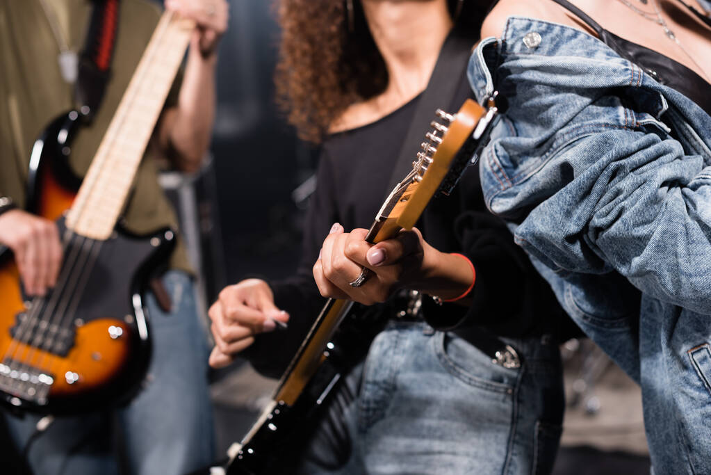 KYIV, UCRAINA - 25 AGOSTO 2020: Vista ritagliata del musicista rock band con chitarristi sfocati sullo sfondo - Foto, immagini