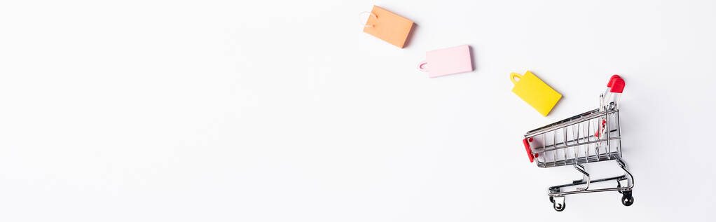 Panoráma lövés színes bevásárló táskák közelében játék kosár fehér háttér - Fotó, kép