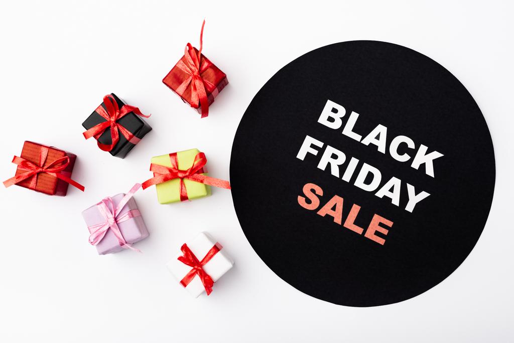 Top view of colorful toy gifts near circle with black friday lettering on white background - Photo, Image