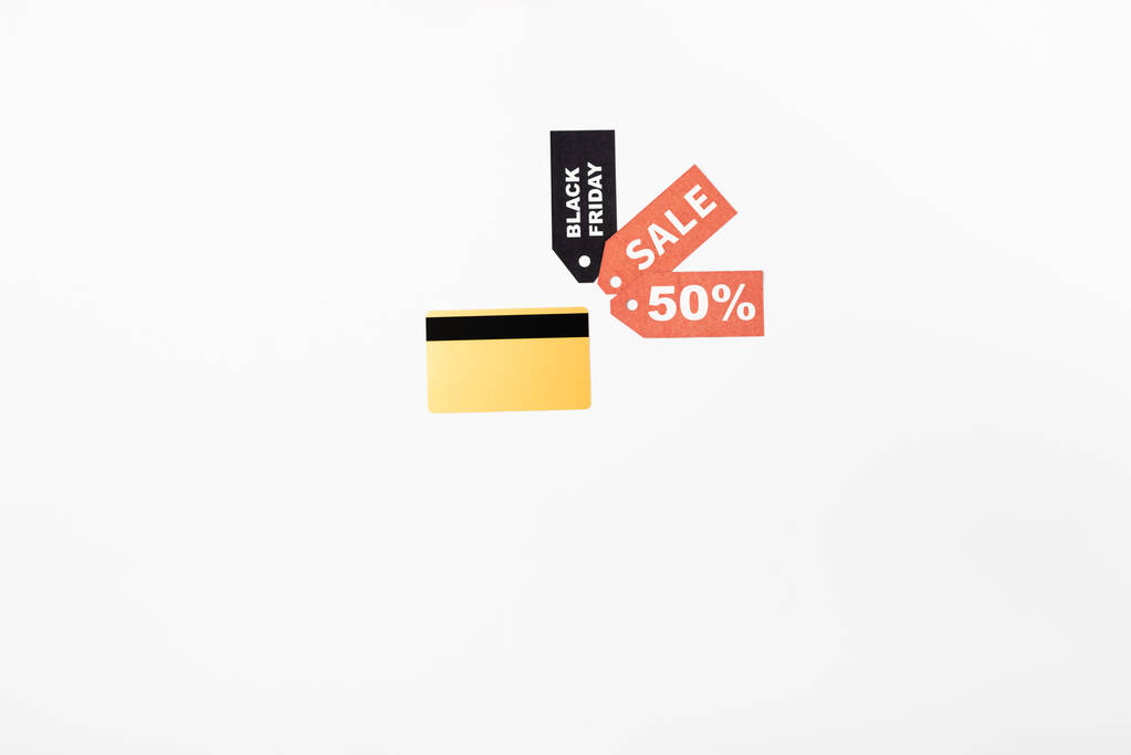 Draufsicht auf Kreditkarten in der Nähe von Preisschildern mit schwarzem Freitag und Verkaufsaufdruck auf weißem Hintergrund - Foto, Bild