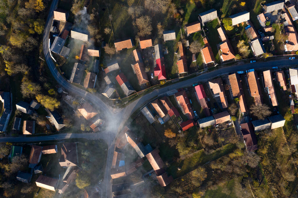 Vista aérea de un dron de una mañana brumosa sobre las calles del pueblo y techos de la casa. Manastireni, Rumania - Foto, imagen