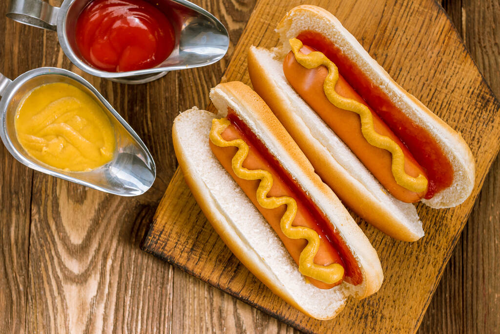 dos perros calientes clásicos con ketchup y mostaza - Foto, imagen