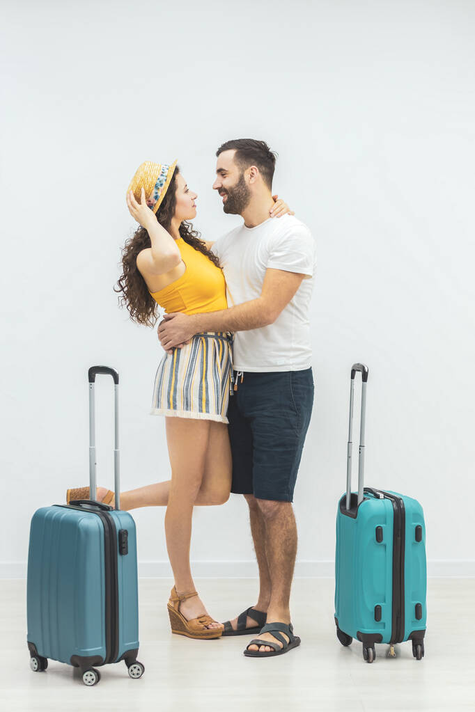 Νεαρό ζευγάρι παίρνει αποσκευές για να ταξιδέψουν στην παραλία. - Φωτογραφία, εικόνα