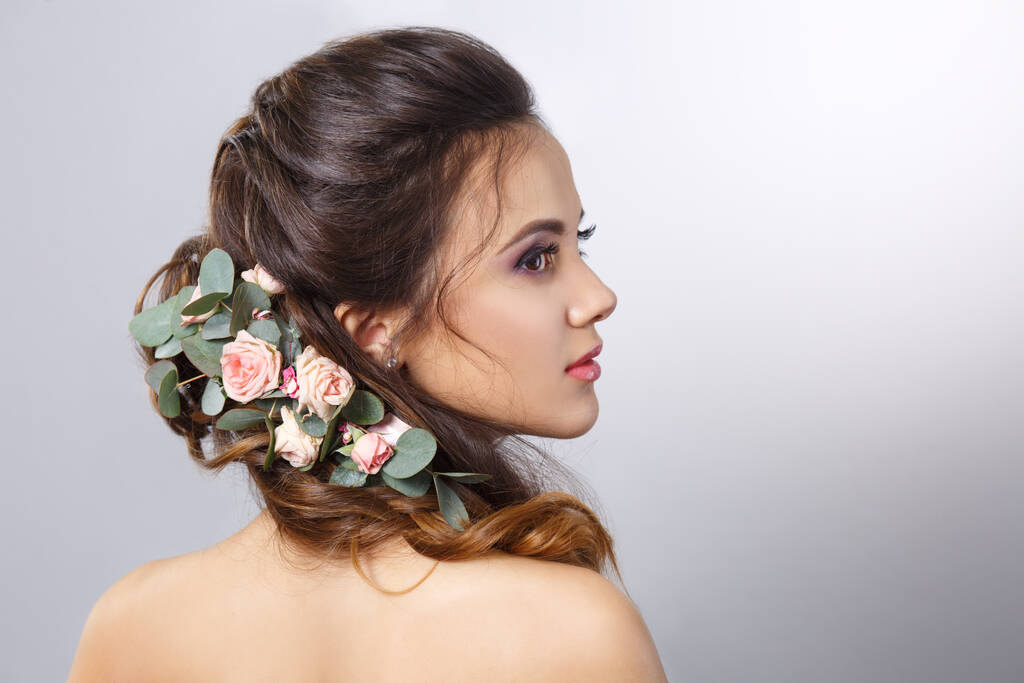 Porträt der schönen Mädchen mit Blumen in ihrer Frisur Rückseite isoliert auf grauem Hintergrund. - Foto, Bild