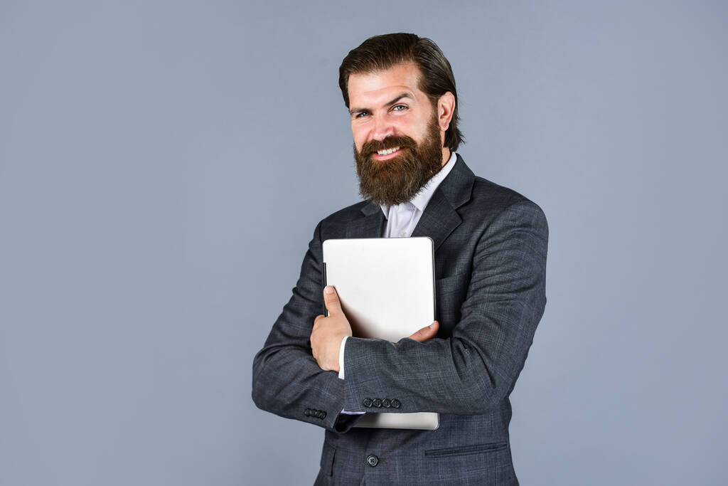 positive mood for working. new technology in modern business lie. happy caucasian bearded hipster with computer. male employee holding finance report and researches in coworking space on laptop - Photo, Image