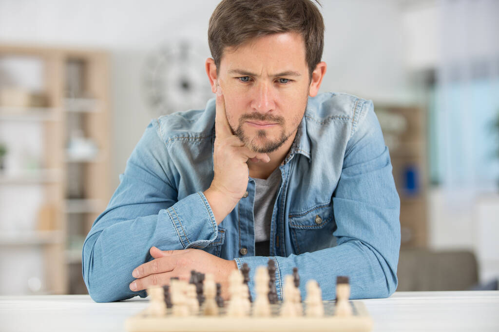 een jonge man en schaken - Foto, afbeelding
