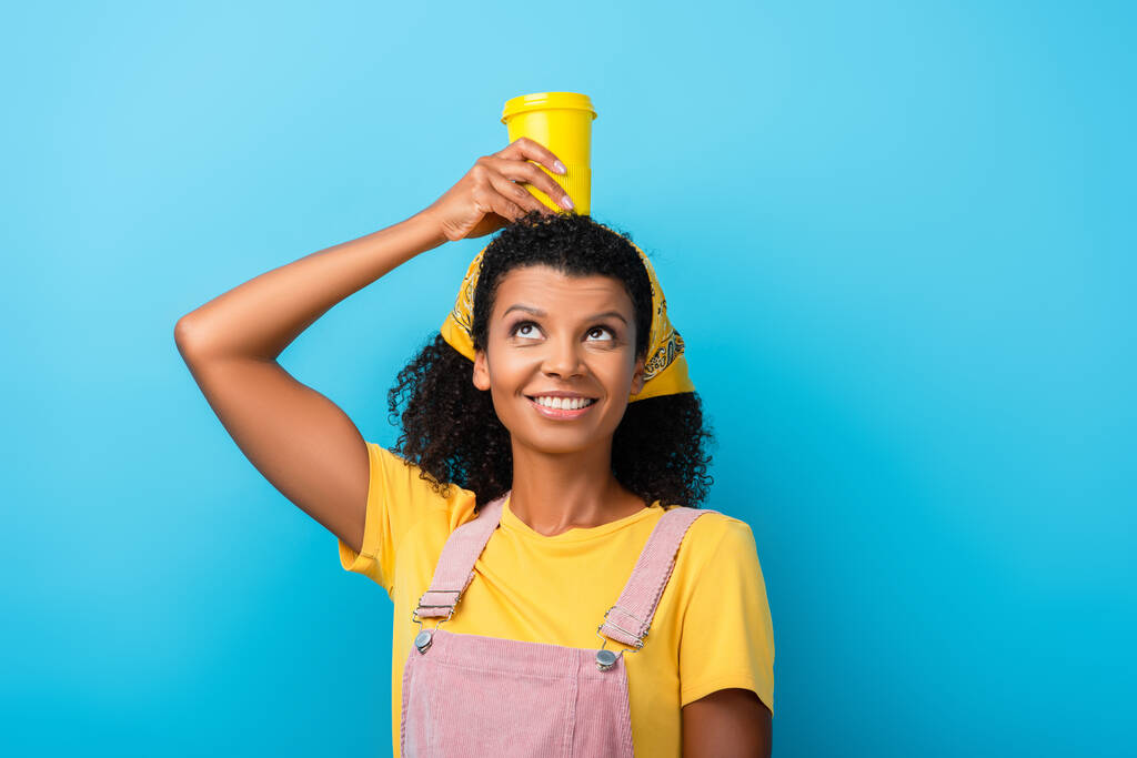boldog afro-amerikai nő kezében újrahasznosítható bögre feje felett a kék - Fotó, kép