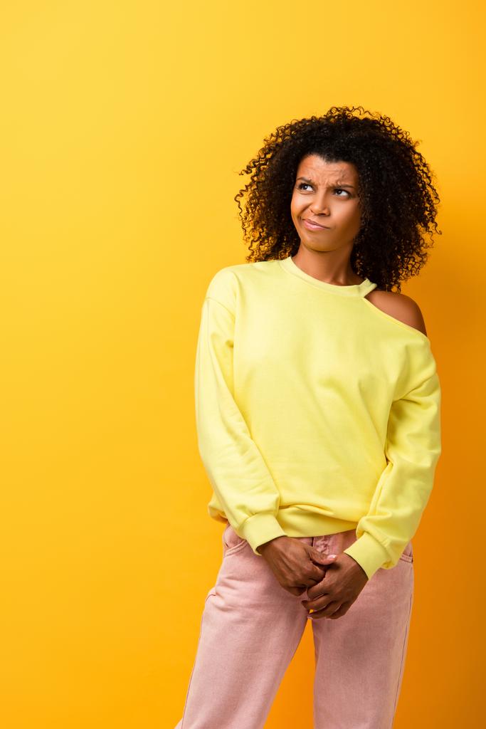 elégedetlen afro-amerikai nő néz félre sárga - Fotó, kép