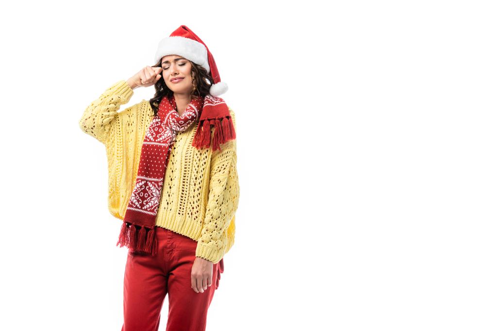donna sconvolta in cappello di Babbo Natale e sciarpa con ornamento pianto isolato su bianco - Foto, immagini