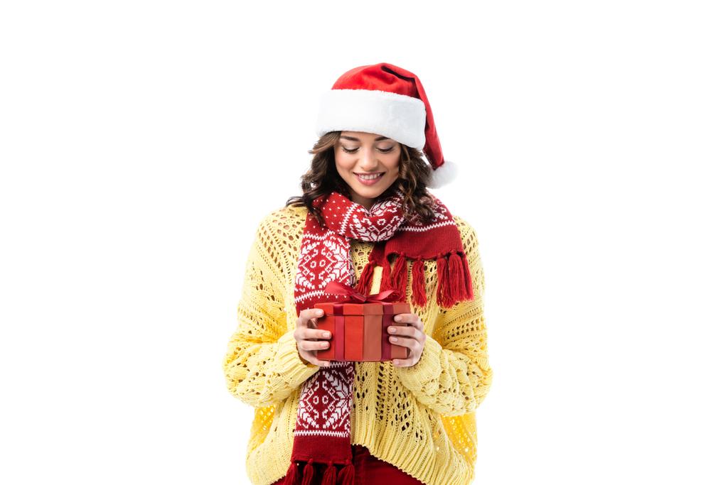 young happy woman in santa hat and red scarf holding present isolated on white - Photo, Image