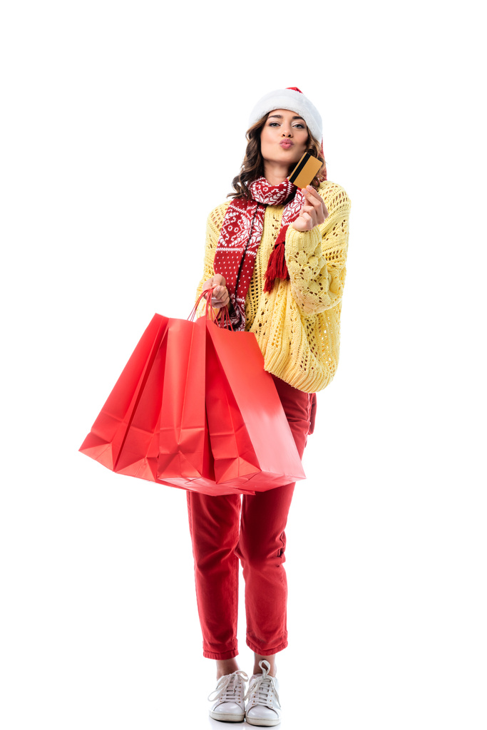 nő kacsa arc, télapó kalap és sál dísz gazdaság bevásárló táskák és hitelkártya elszigetelt fehér  - Fotó, kép