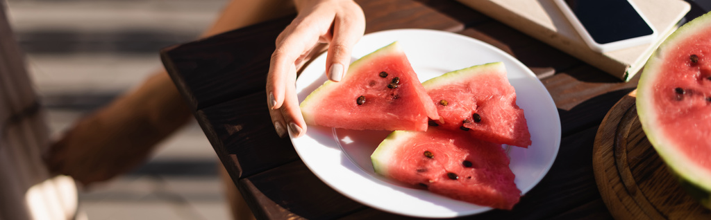 cropped view of woman taking watermelon slice from plate, horizontal banner - Photo, Image