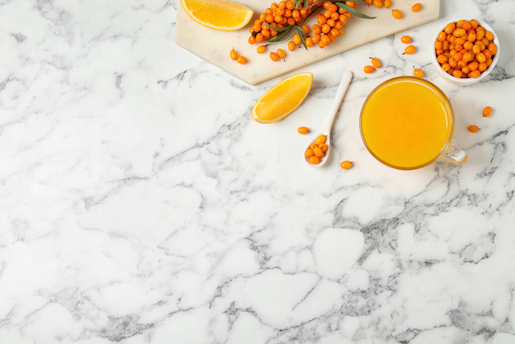 Fresh sea buckthorn tea on white marble table, flat lay. Space for text - Photo, Image