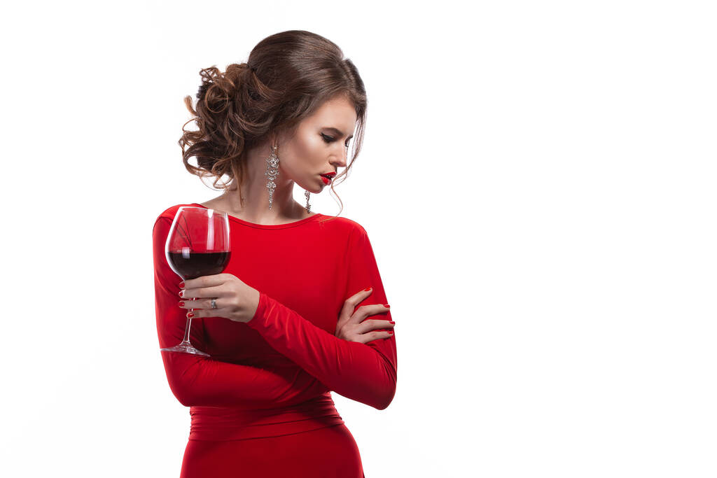 Женщина с макияжем, прическа в красном платье позируя со стаканом винограда на белом фоне, изолировать - Фото, изображение