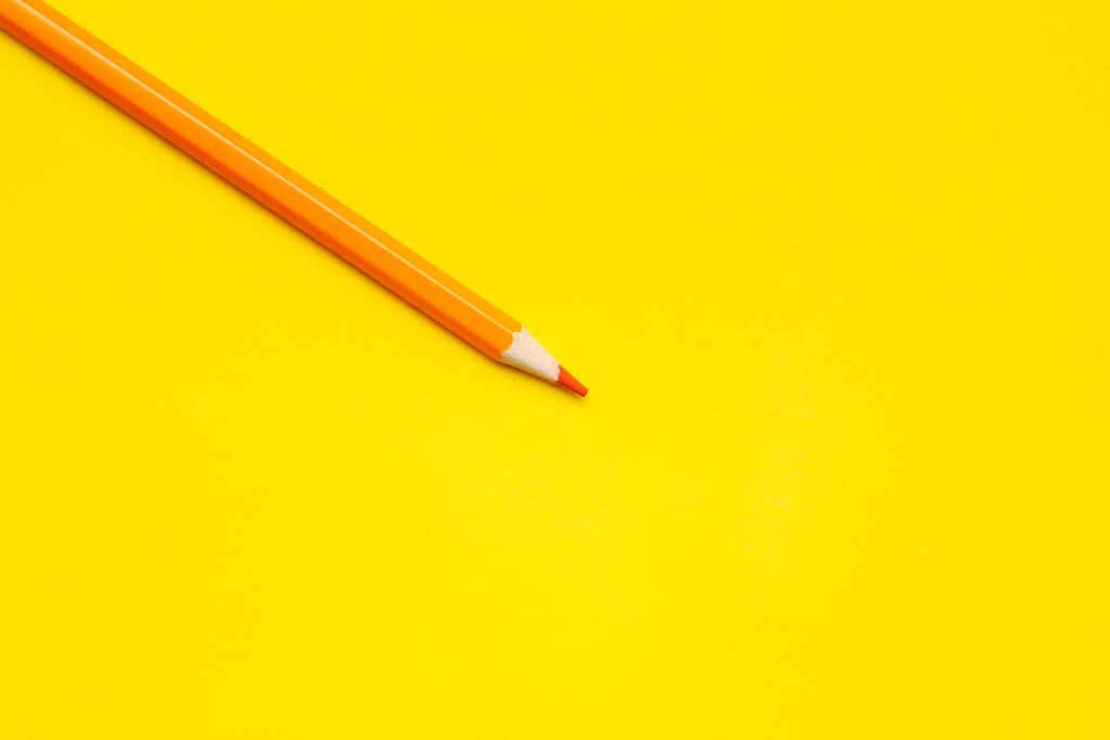 明るい黄色の背景に斜めのオレンジ色の鋭い木製の鉛筆、隔離された、コピースペース、モックアップ - 写真・画像