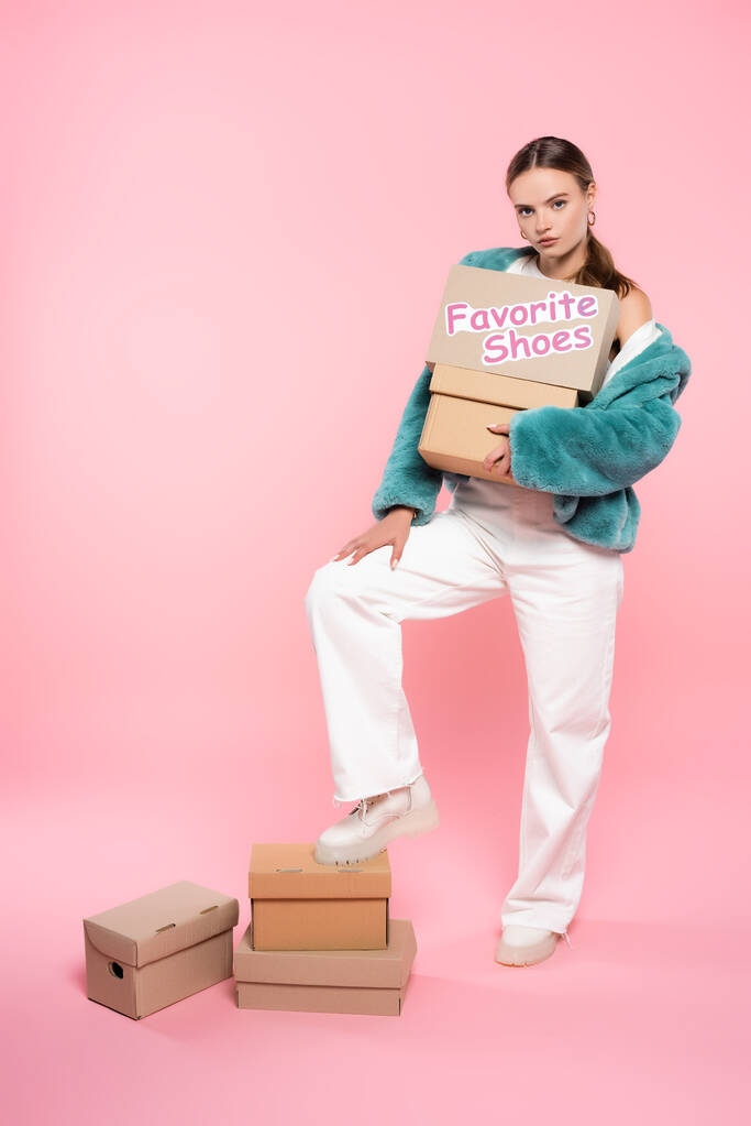 ピンクのパッケージの近くに好きな靴のレタリングとサングラス保持ボックスのスタイリッシュな女性,黒の金曜日のコンセプト - 写真・画像