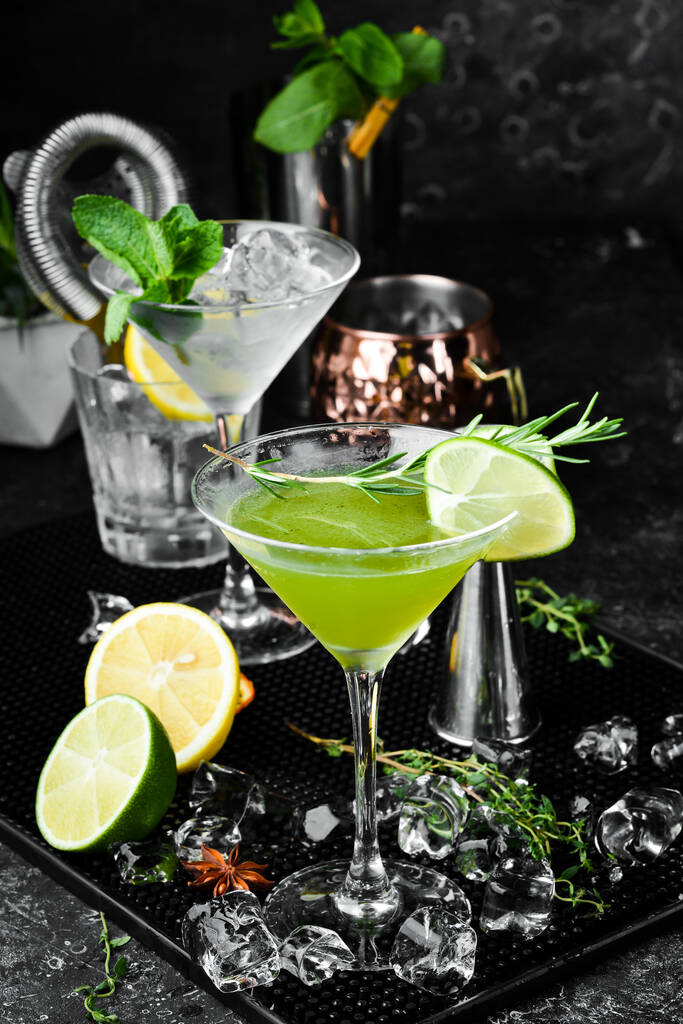 Groene alcoholische cocktail met limoen en rozemarijn. Op een zwarte stenen achtergrond. Menubalk. - Foto, afbeelding