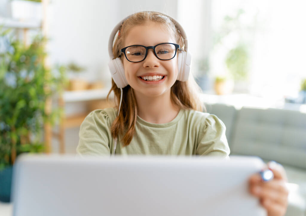 Повернутися до школи. Щаслива дитина сидить за столом. Дівчина робить домашнє завдання або онлайн-освіта
. - Фото, зображення