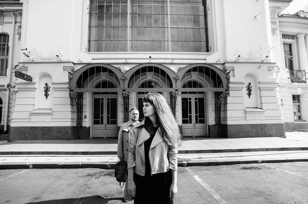в парі коханих - чоловік з вінтажного пальто в сірій шкіряній куртці - прогулянка на Вітебському залізничному вокзалі в Санкт-Петербурзі, щасливий і обіймів - Фото, зображення