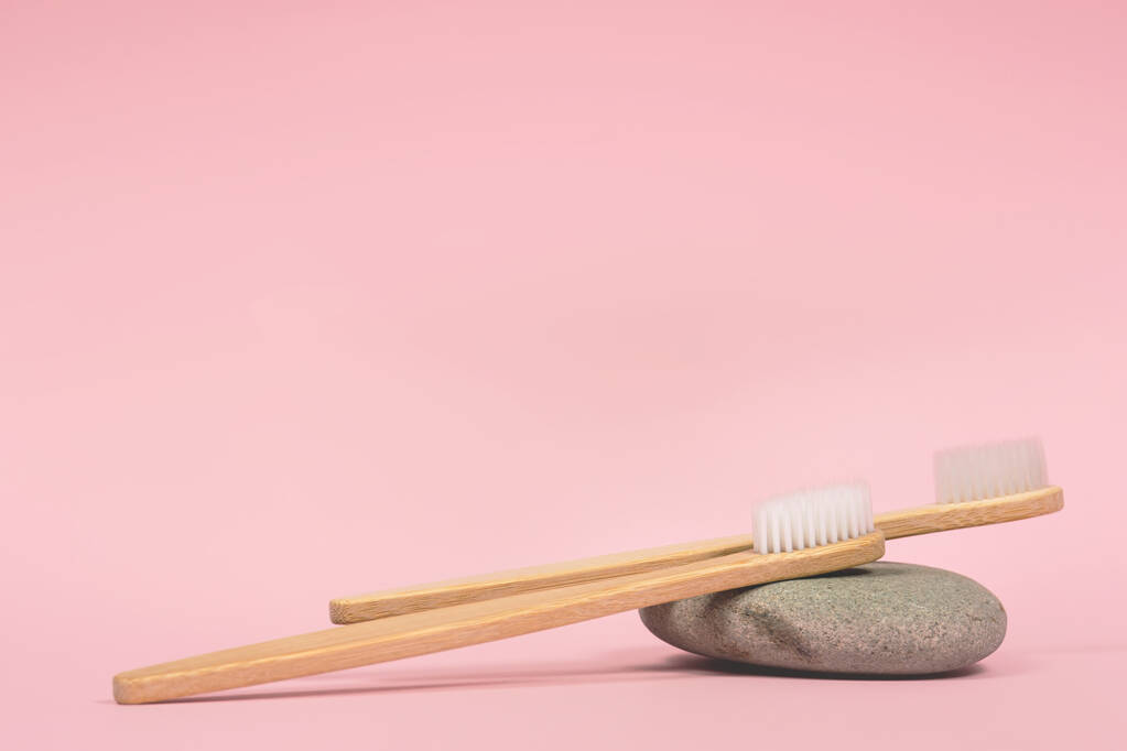 spazzolini di bambù su uno sfondo rosa pietra posto per il testo - Foto, immagini