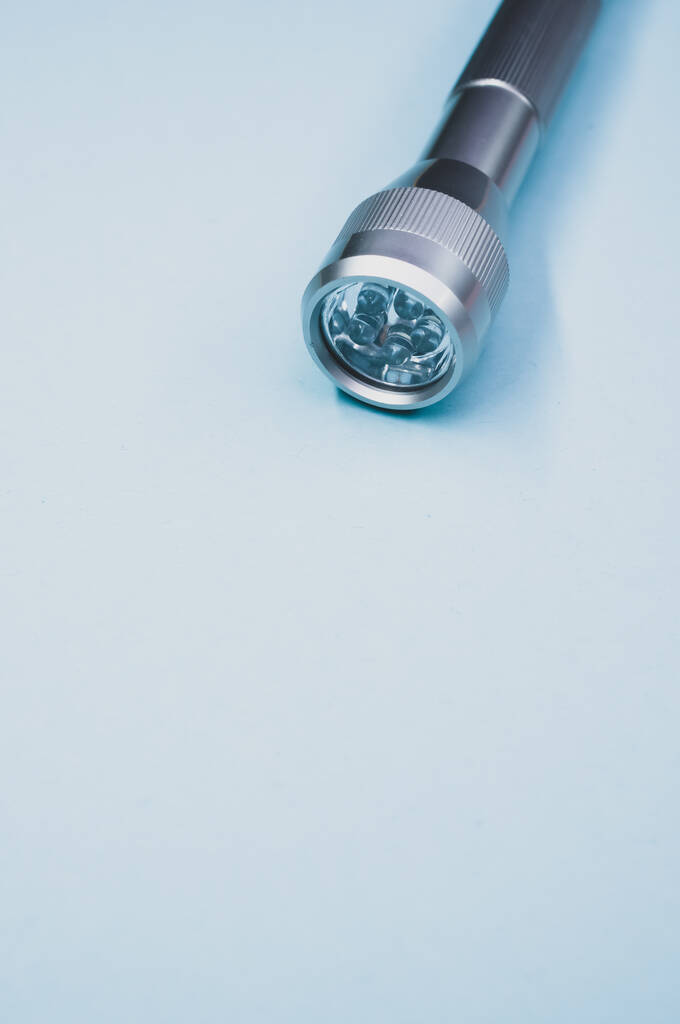 Un disparo vertical de una linterna sobre una superficie azul - Foto, imagen