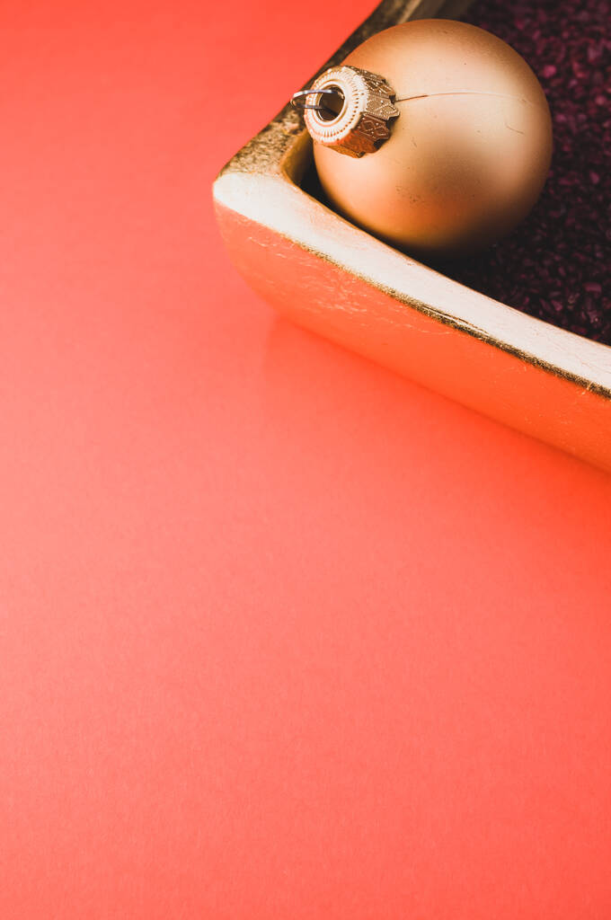 Egy függőleges lövés a karácsonyi díszek egy luxus tál tele kis piros sziklák rózsaszín háttér - Fotó, kép