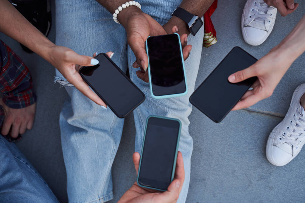 Чотири людини демонструють смартфони в руках
 - Фото, зображення