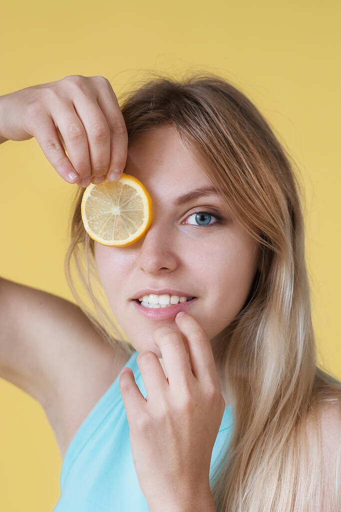 Portrét mladé ženy, jak se směje s citrónem. - Fotografie, Obrázek