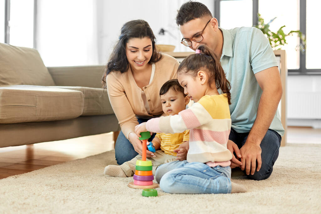 ευτυχισμένη οικογένεια παίζει με πυραμίδα παιχνίδι στο σπίτι - Φωτογραφία, εικόνα