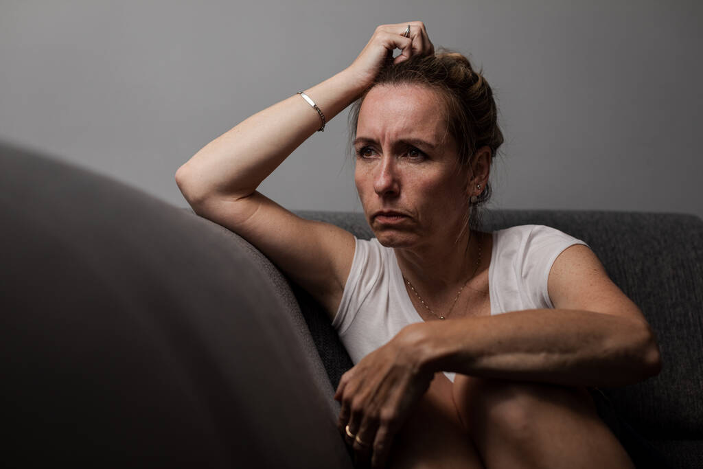 Mujer deprimida de mediana edad en casa sintiéndose triste, sola, ansiosa (imagen tonificada en color) - Foto, imagen