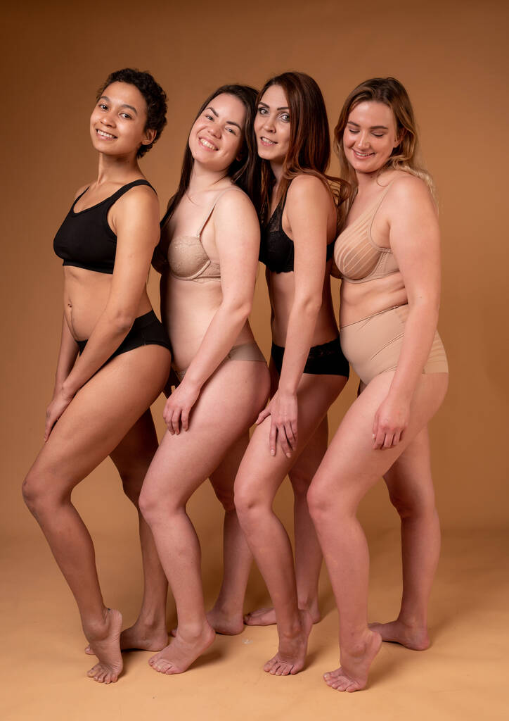Kauniita lihavia tyttöjä mustissa alusvaatteissa vaaleanpunaisella taustalla. Keho positiivinen käsite. Ryhmä naisia, joilla on erilainen vartalo ja etninen tausta - Valokuva, kuva