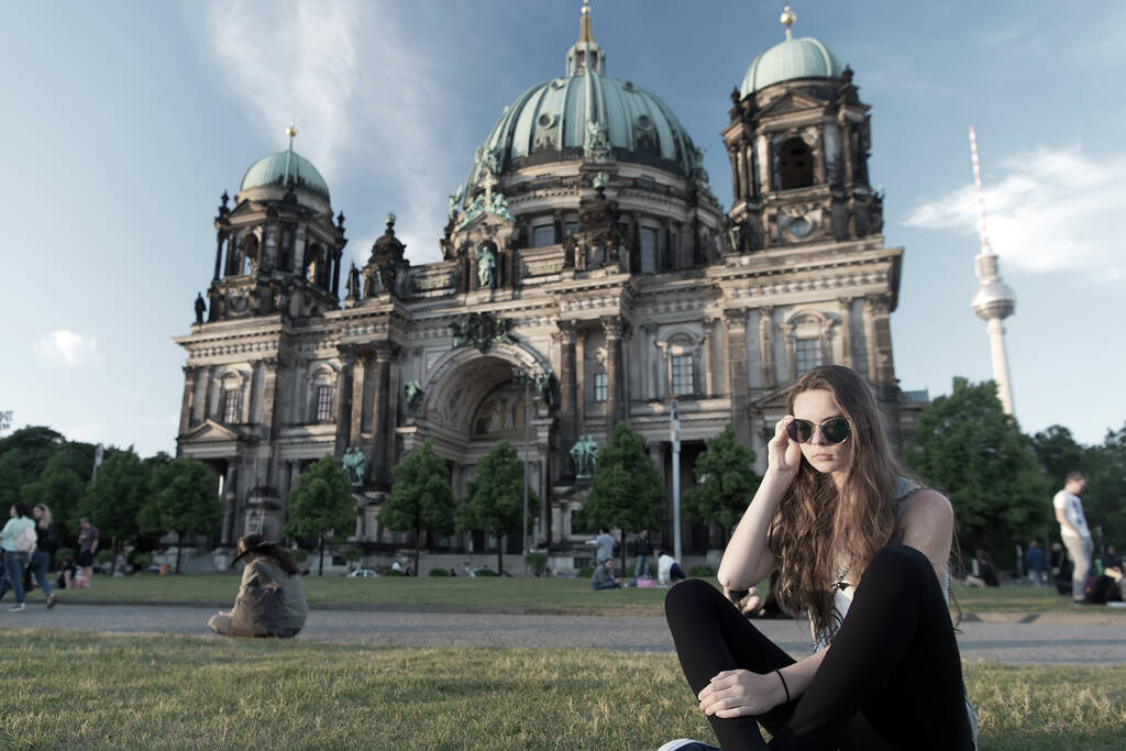 Симпатичная девушка, сидящая перед Берлинским собором в зонтиках. - Фото, изображение